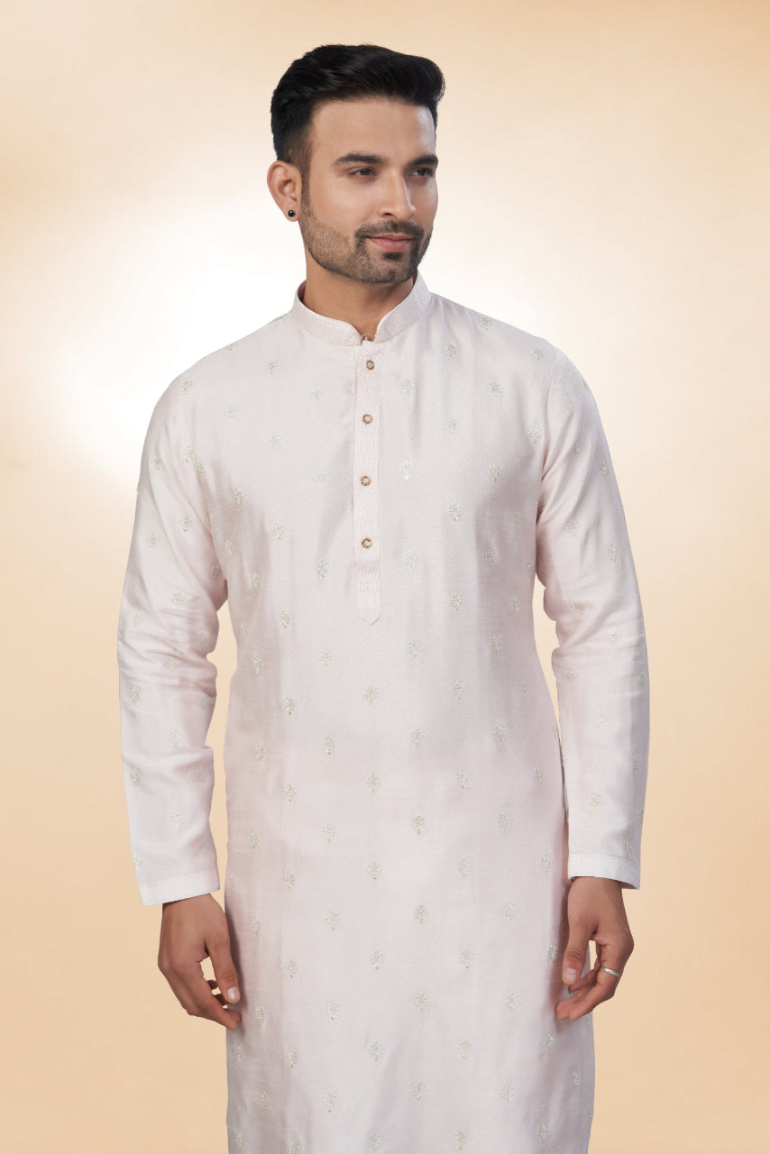 Man wearing a white kurta with a beige background