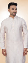 Man wearing a white kurta with a beige background