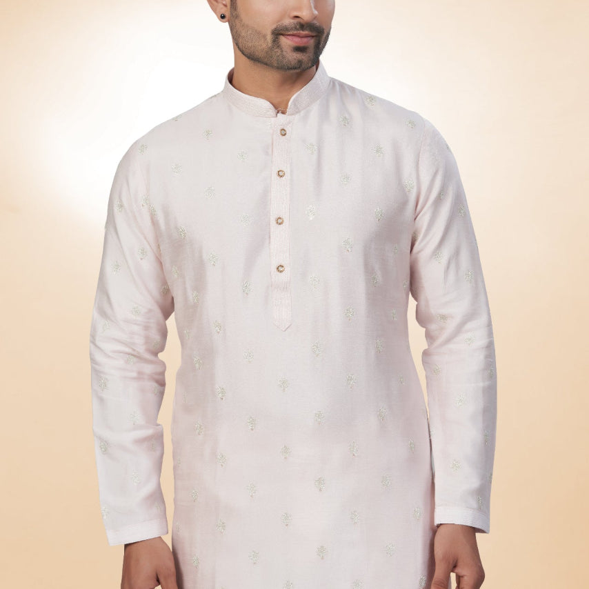 Man wearing a white kurta with a beige background